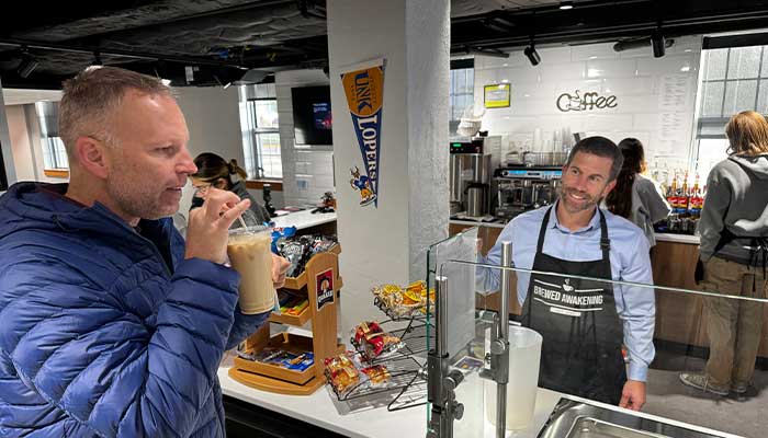 jon watts making a cup of coffee to travis as a guest barista