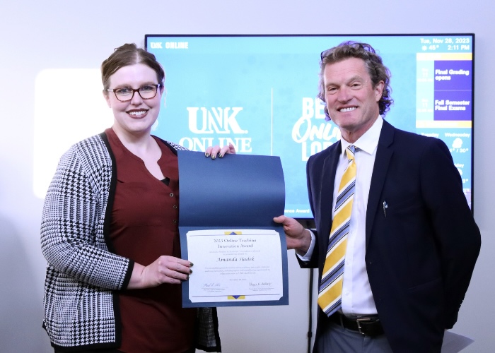 Woman and man holding certificate and smiling at camera.