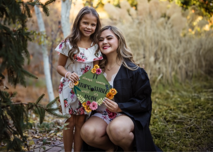Kara with her daughter holding graduation cap.