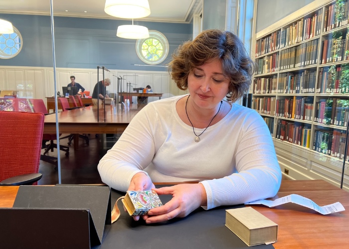 Christy looking at miniature book at Harvard.