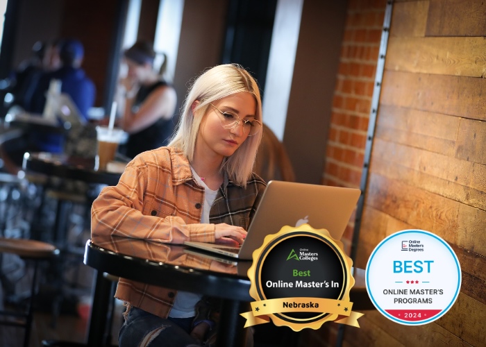 Woman at a coffee shop table with her laptop open.