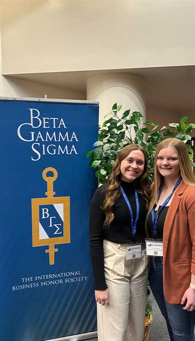 Shayli and Emily in front of BGS Sign on Day 1