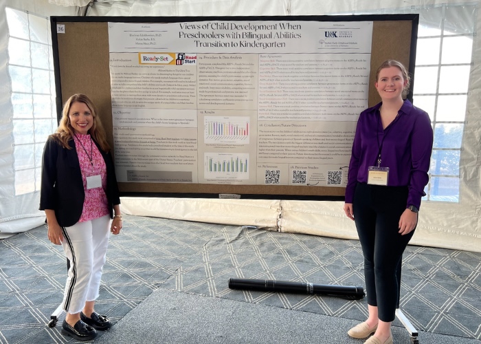 Two women standing in front of a research poster.