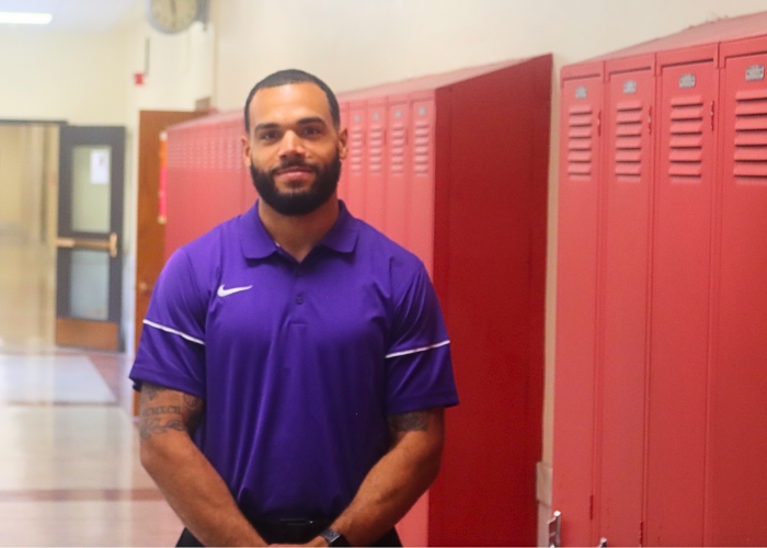 Man standing in front of school lockers.