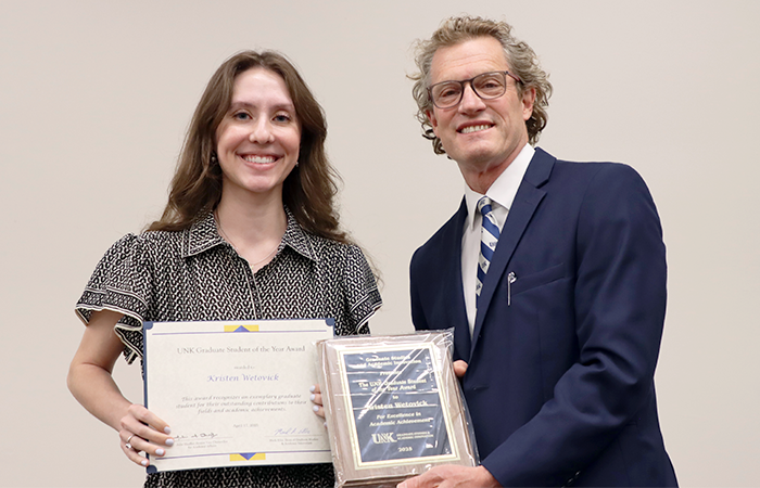 Kristen receiving her plaque and certificate from Dean of Graduate Studies, Dr. Mark Ellis.