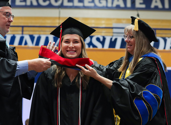 A UNK graduate receiving her academic hood at UNK's graduation ceremony.