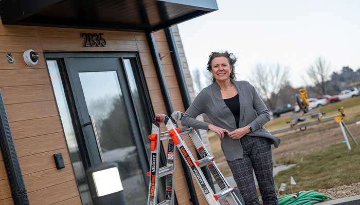 Therese standing in front of the newest affordable housing apartment in Kearney