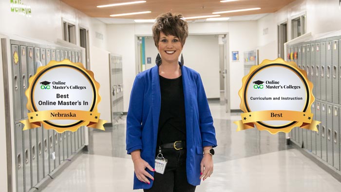 Woman standing in a school hallway. Two badges are on either side of her. One reads, "Best Online Master's in Nebraska" and the other, "Curriculum and Instruction Best."