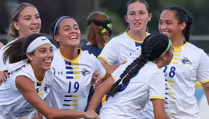 student athletes celebrate while playing soccer