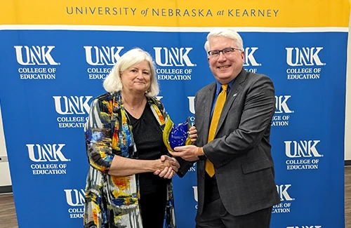 Betty Medinger receiving her award from Dean reid