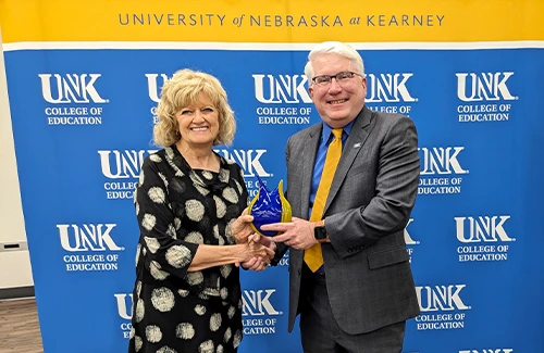 Penny Gildea receiving her award from dean reid