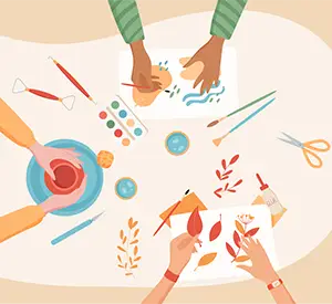 Overhead illustration of hands doing arts and crafts with paint, brushes, scissors, and colorful paper leaves on a table.