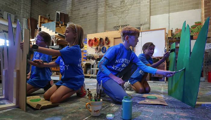 students paint set pieces