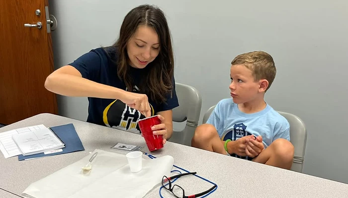 an instructor demonstrates an activity to a student in a classroom