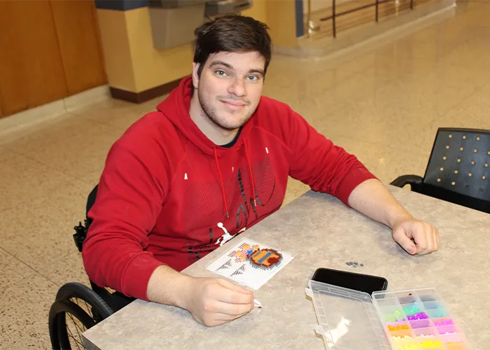a student in a wheelchair sits at a desk