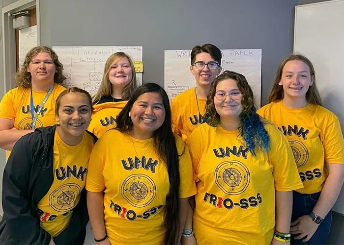 students in unk trio shirts pose for a photo
