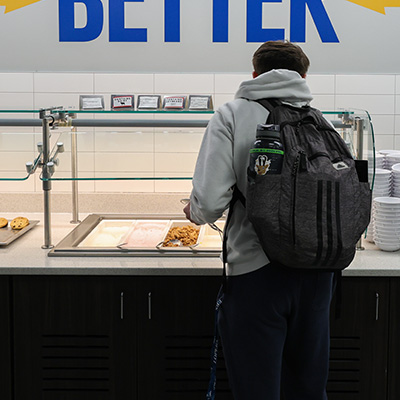a student takes food from a buffet