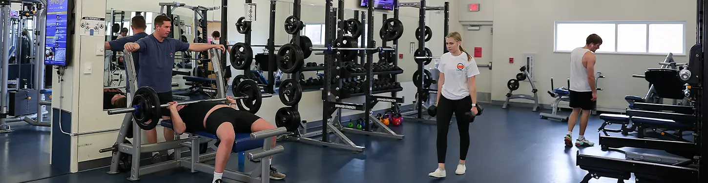 students using weights in the wellness center