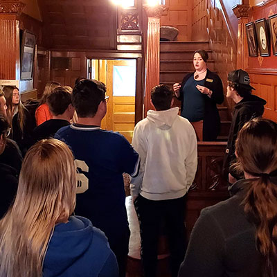 a groups listens to a tour guide inside the frank museum