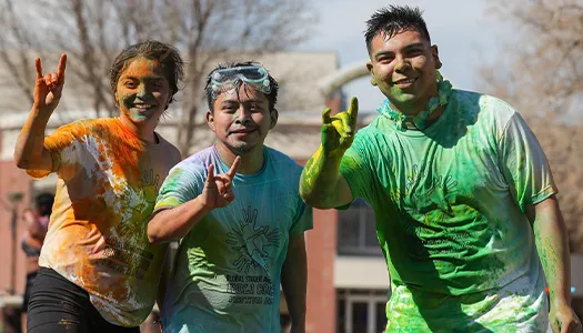 students covered in vibrant chalk at a holi event