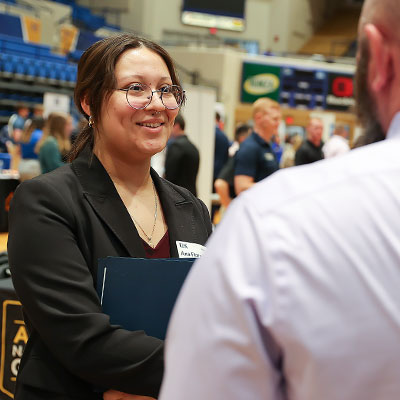 a student talks to a rep at the career fair