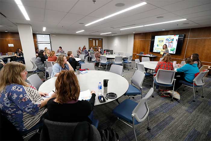 Conference room with round tables and large display screen