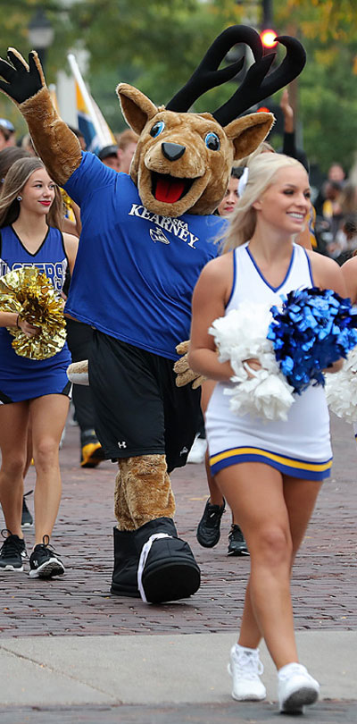 cheerleaders and the louie mascot walk during the homecoming parade