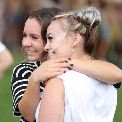 two students hug during a bid day event