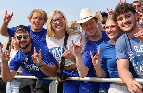 students and parents throw the lopes at the homecoming football game