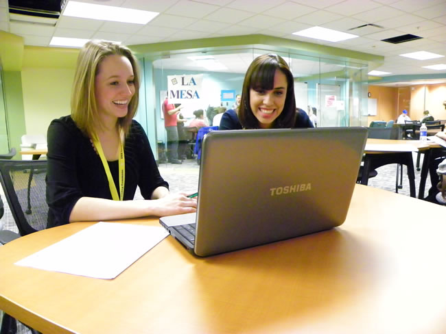 Students working together on a laptop in the UNK Writing Center