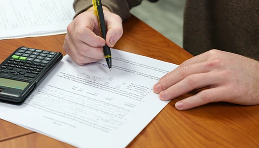 close up of a hand writing out math homework