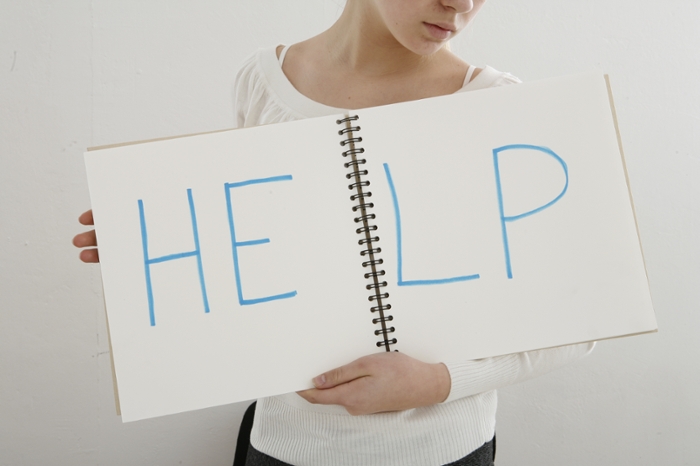 Person holding a sign that says Help