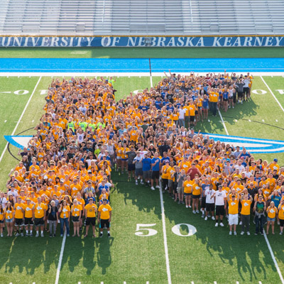 UNK students on football field in K formation