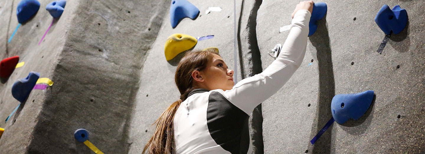 Student climbing rock wall