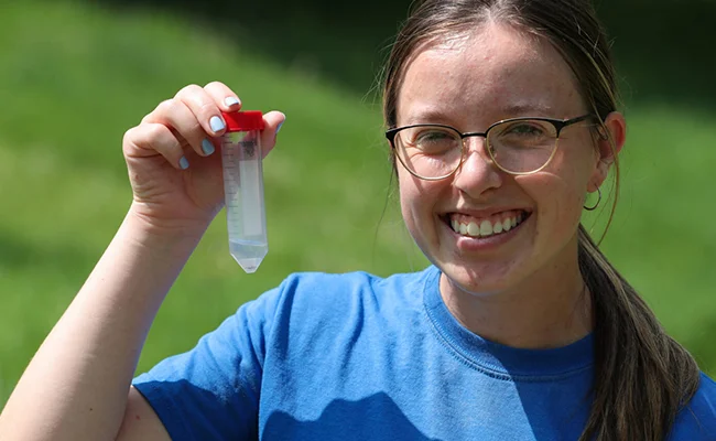 a biology student holds up a sample