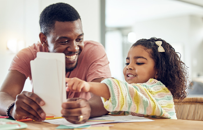 a man helps a young child with flash cards