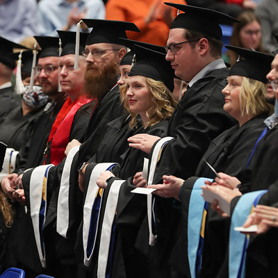 students at commencement wearing graduation robes