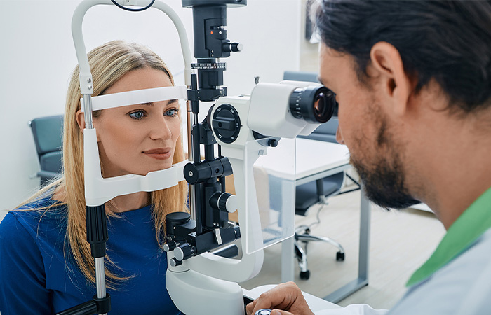 an optometrist works with a patient