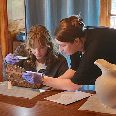 an instructor helps a student examine an artifact