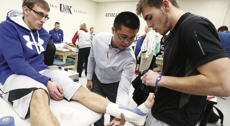 students assisting another's foot injury