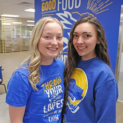 two young women pose for a photo in the dining hall