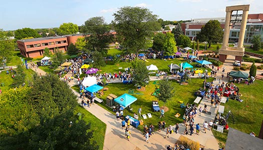Aerial shot of the Blue Gold welcome event, with students walking past booths and tents on a sunny evening